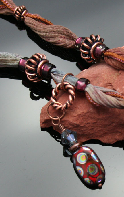 close-up photo of the Czech peacock bead and Swarovski crystal dangles