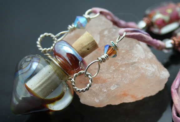 A beautiful blush-colored glass aromatherapy bottle necklace on pink watercolor silk cord with fantasic glass beads
